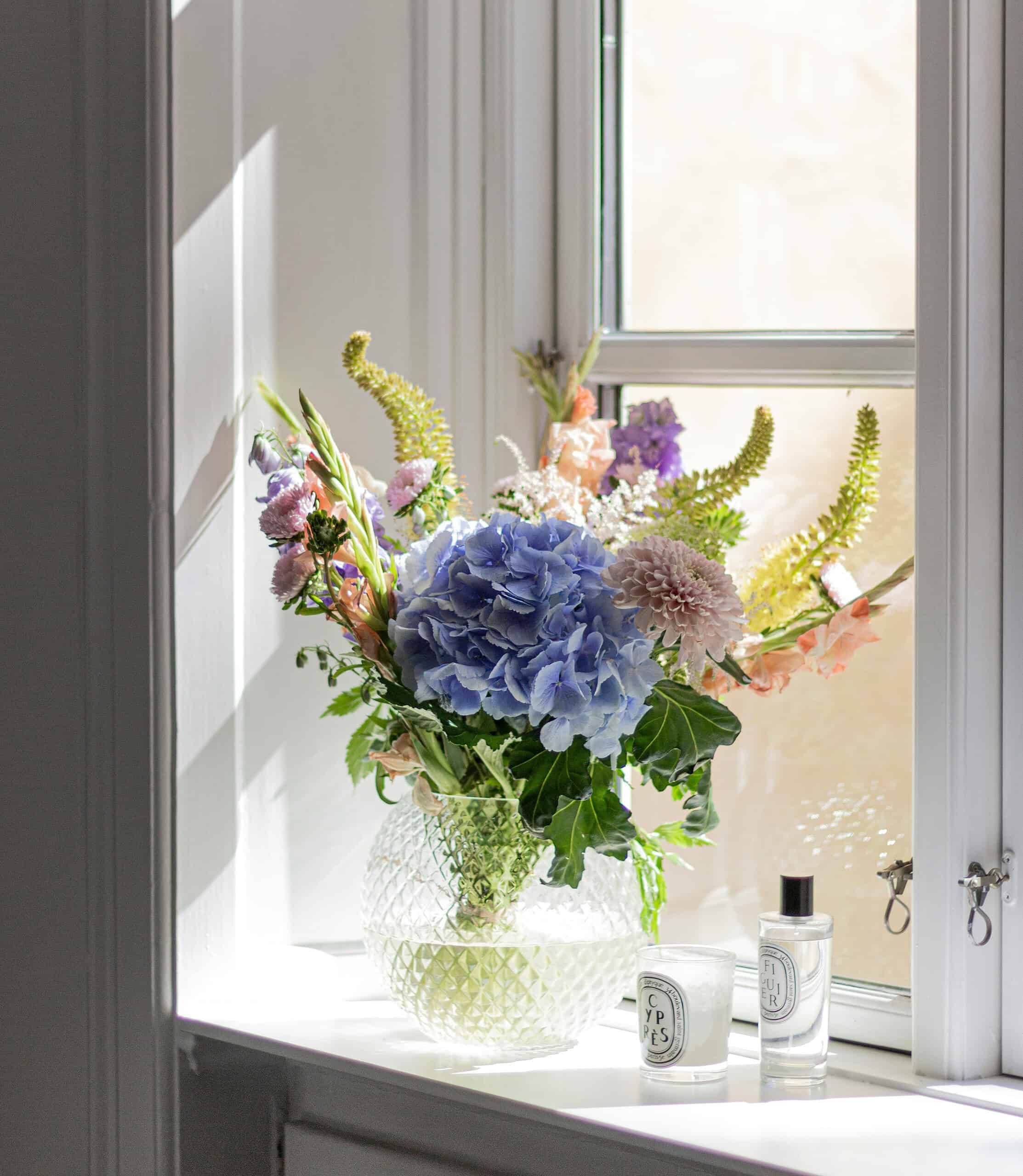 Schnittblumen als Blumenstrauß in einer Vase am Fenster