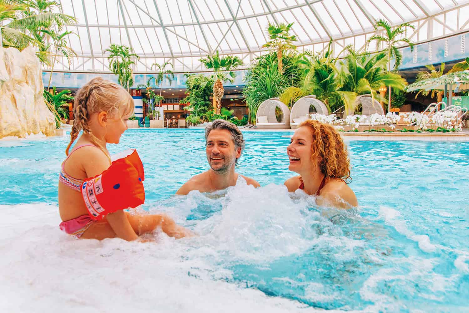 Eltern mit einem Kleinkind im Schwimmbecken innen