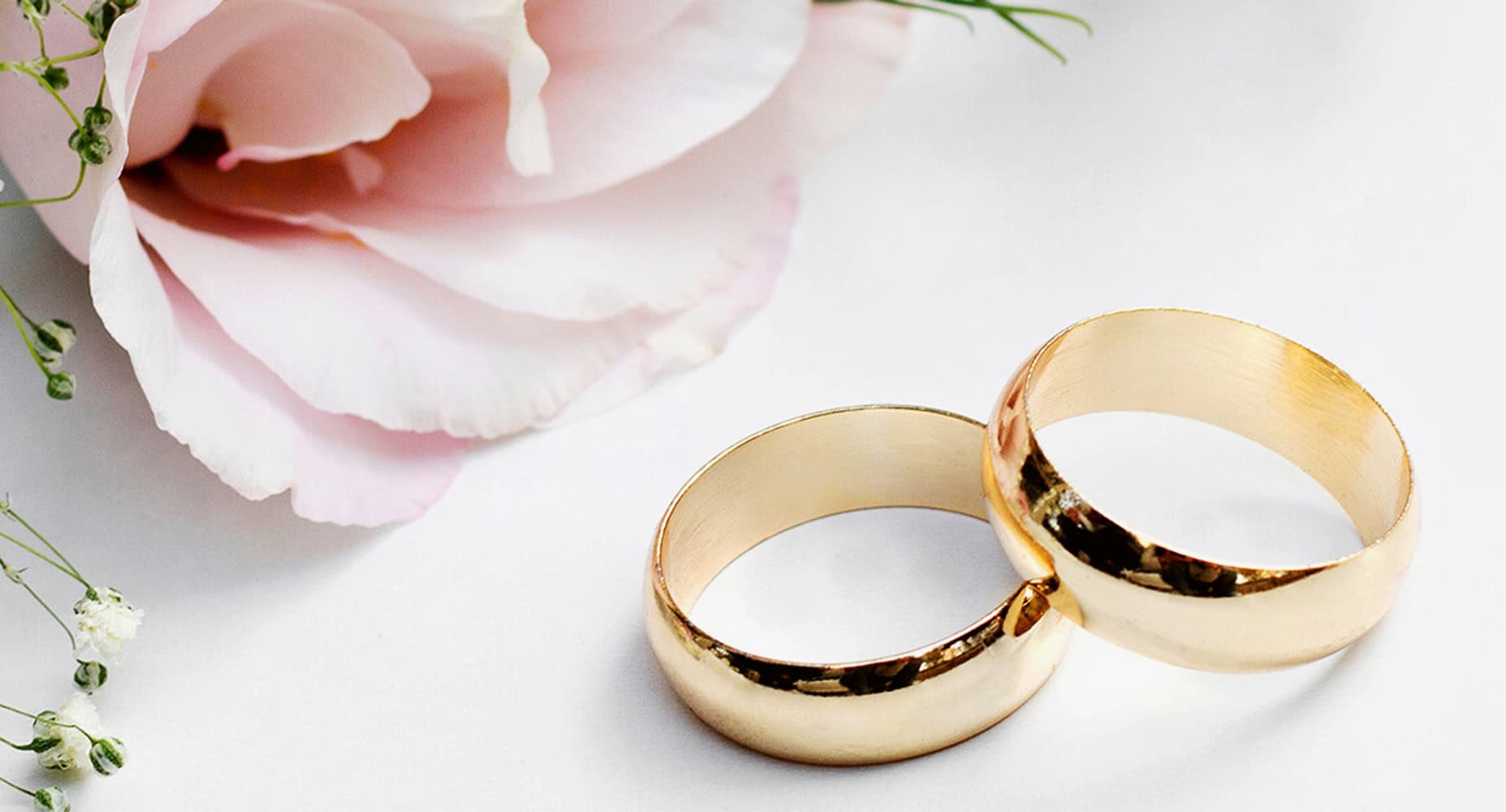 goldene Eheringe mit einer Rose