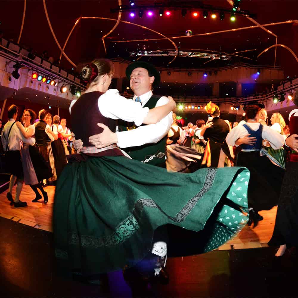 Paar tanzt in einem Ballsaal in bayerische Tracht