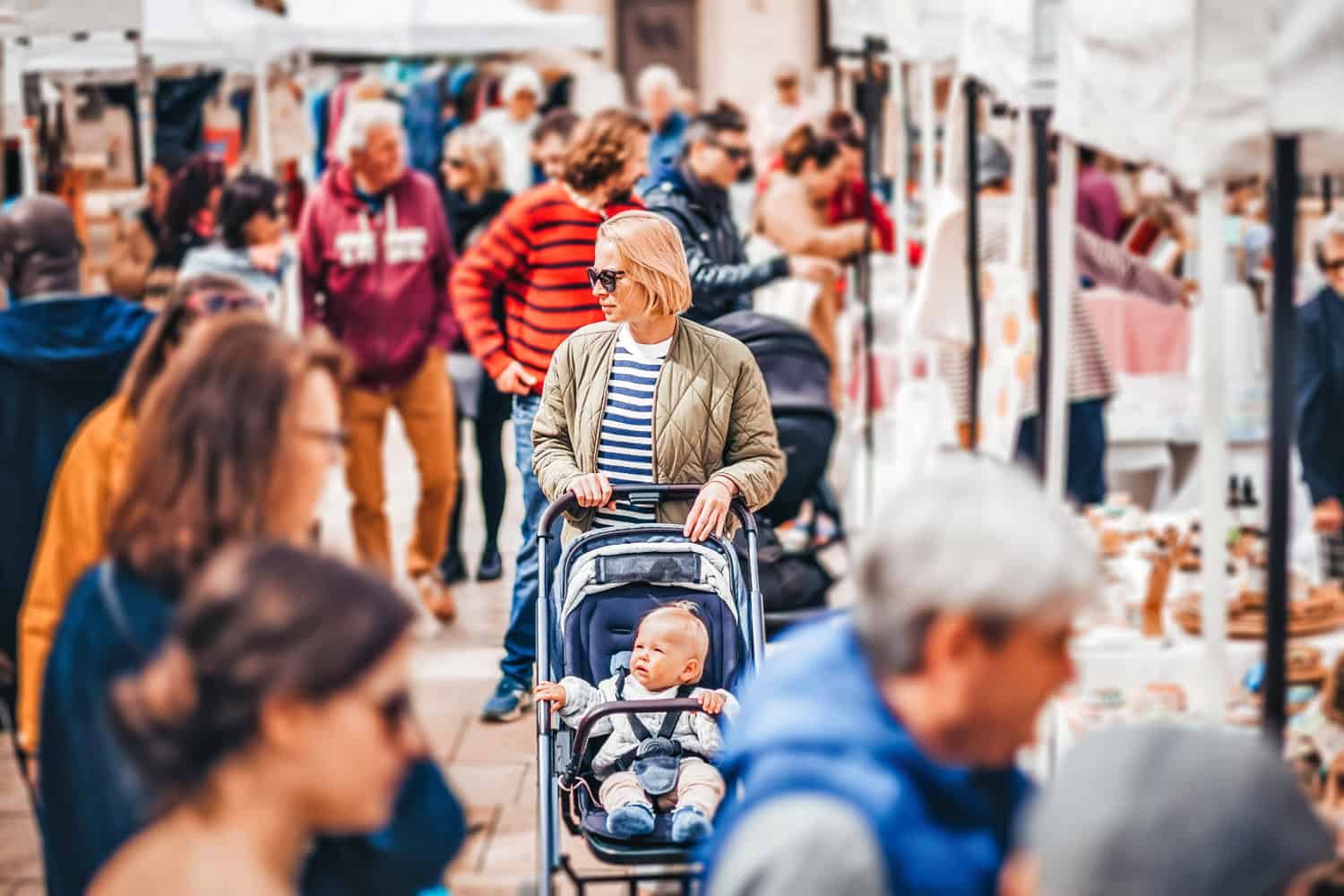 Frau mit Kinderwagen auf einem Flohmarkt